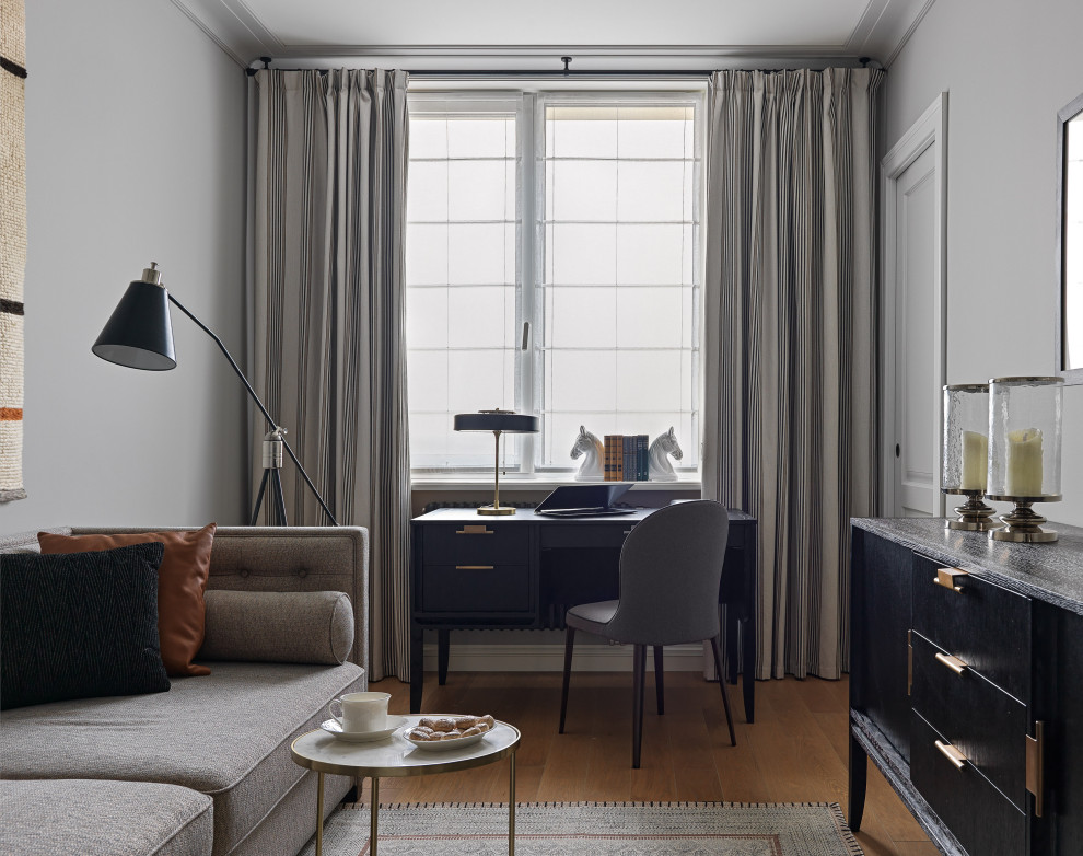 Diseño de despacho clásico renovado con paredes grises, suelo de madera en tonos medios, escritorio independiente y suelo marrón
