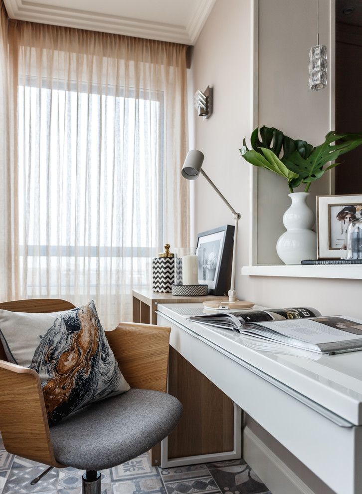 Mittelgroßes Modernes Arbeitszimmer mit Arbeitsplatz, grauer Wandfarbe, freistehendem Schreibtisch und buntem Boden in Sonstige