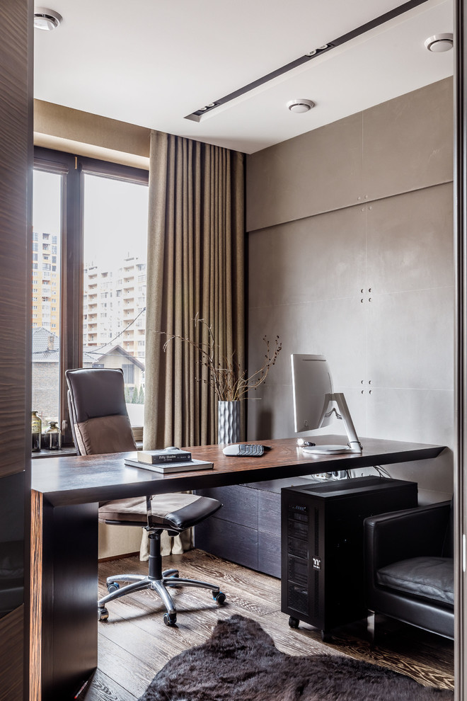 Esempio di uno studio minimal con pareti grigie, pavimento in legno massello medio, scrivania incassata e pavimento marrone