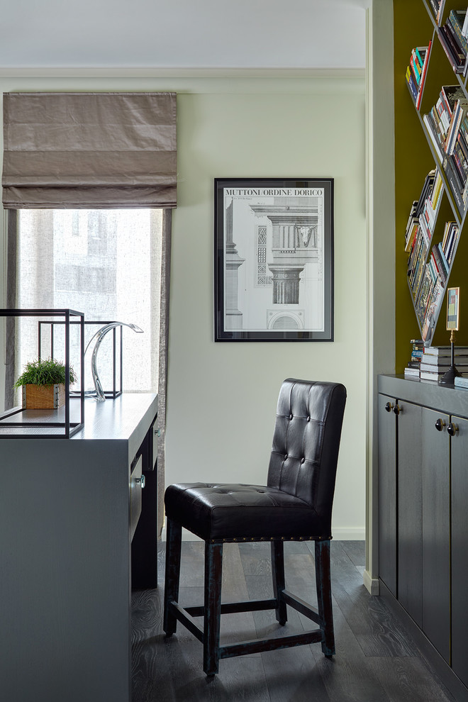 Immagine di un ufficio minimal con pareti verdi, parquet scuro, scrivania autoportante e pavimento nero