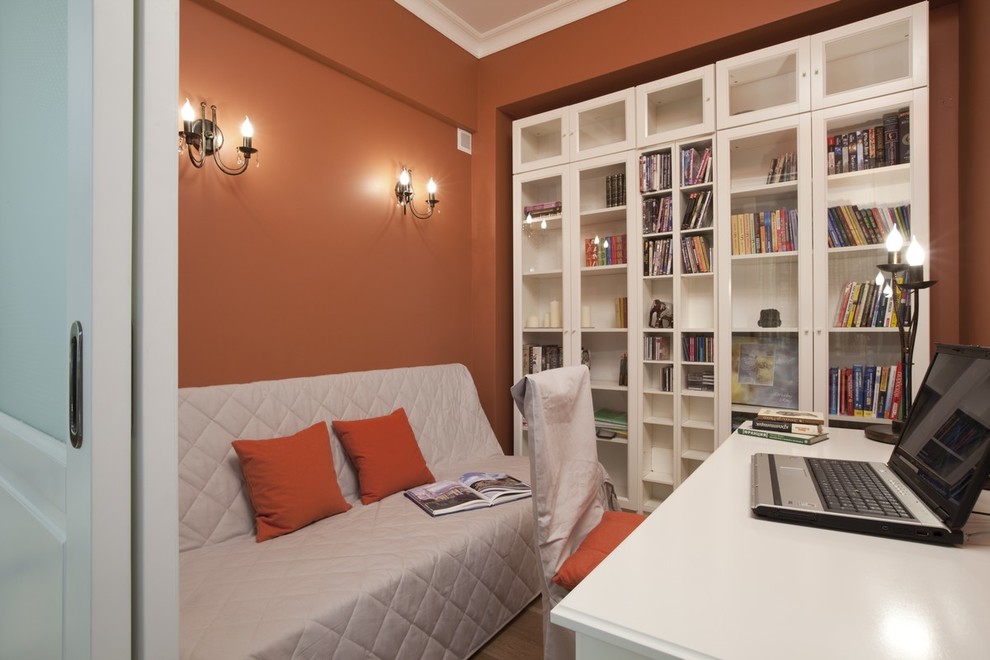 Idee per un piccolo studio contemporaneo con scrivania autoportante, libreria, pareti rosse e parquet chiaro