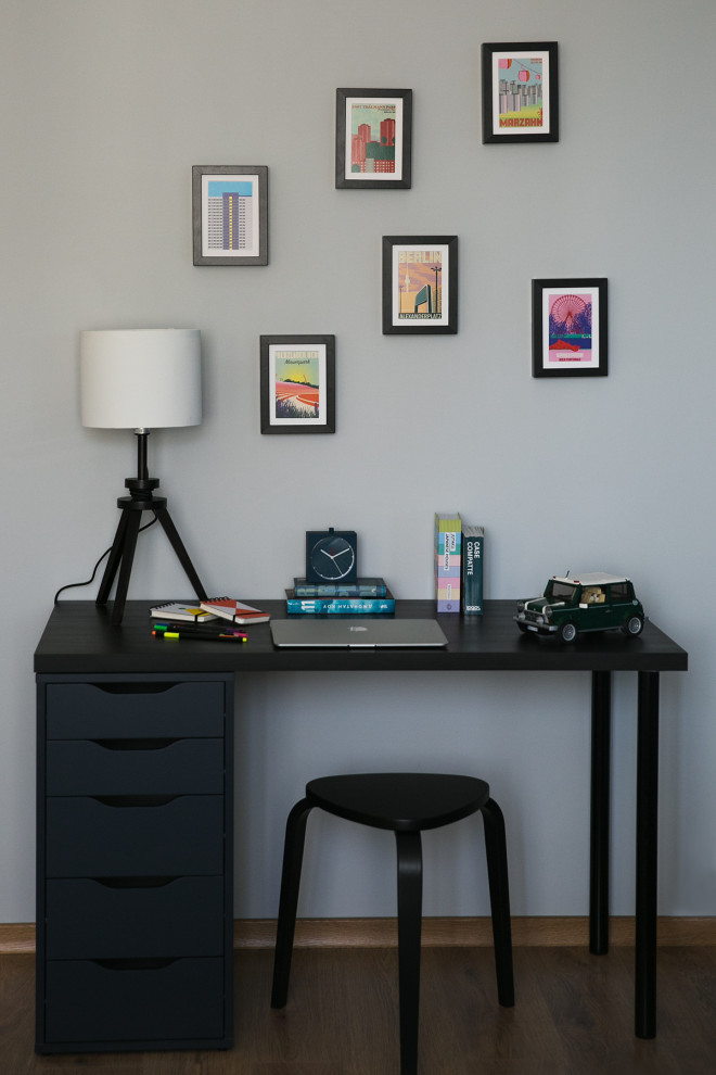 Imagen de despacho nórdico pequeño con paredes grises, suelo laminado, escritorio independiente y suelo marrón