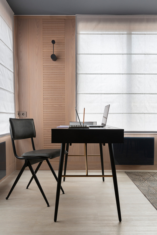 Diseño de despacho contemporáneo grande con paredes beige, suelo de madera clara, escritorio independiente y suelo beige