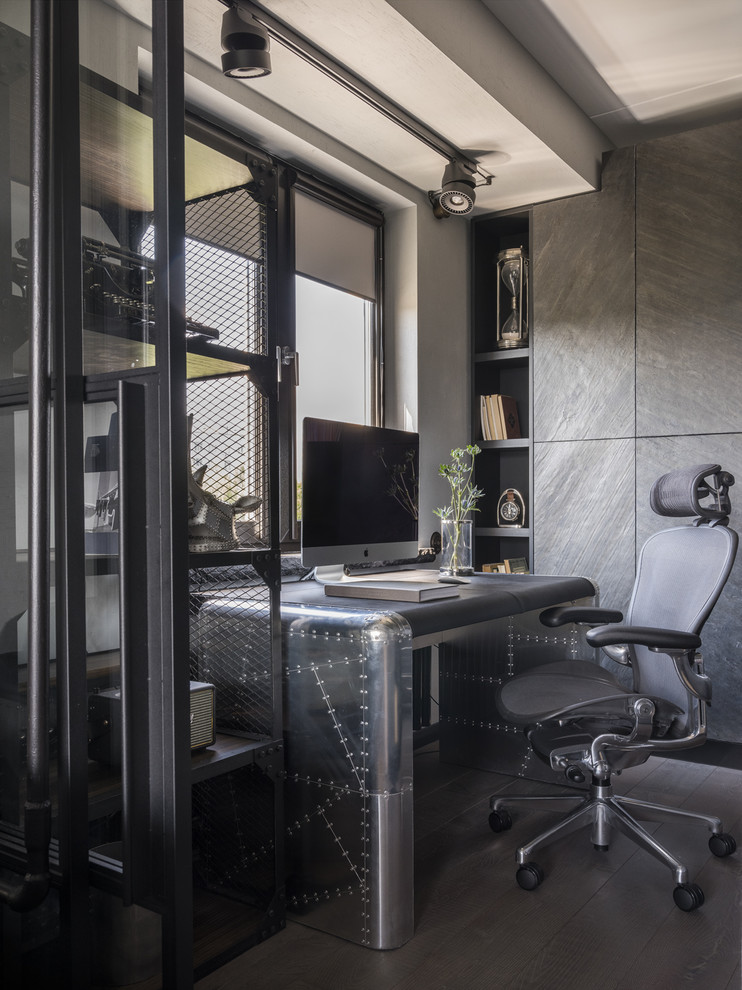 Пример оригинального дизайна: рабочее место в стиле лофт с серыми стенами, темным паркетным полом и отдельно стоящим рабочим столом