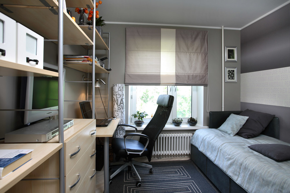 Modern inredning av ett litet arbetsrum, med grå väggar och målat trägolv