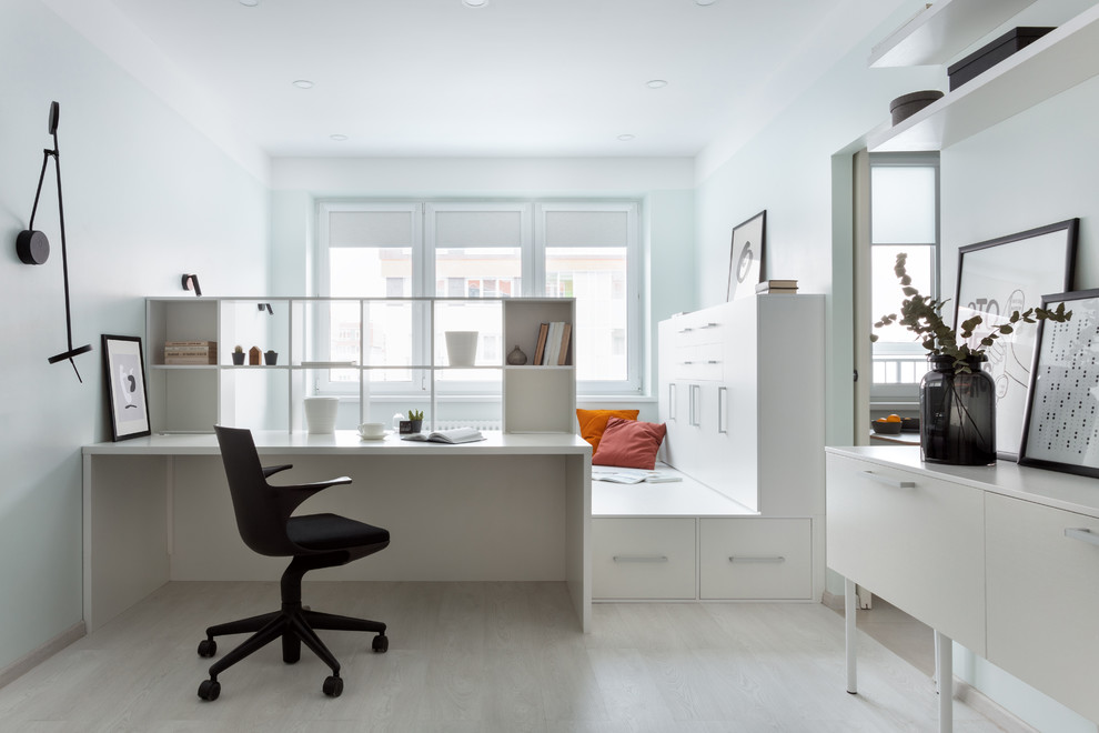 Imagen de despacho actual sin chimenea con suelo de madera clara, suelo beige, paredes azules y escritorio empotrado