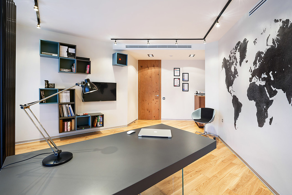 Inspiration för ett mellanstort funkis hemmabibliotek, med vita väggar, mellanmörkt trägolv och ett fristående skrivbord