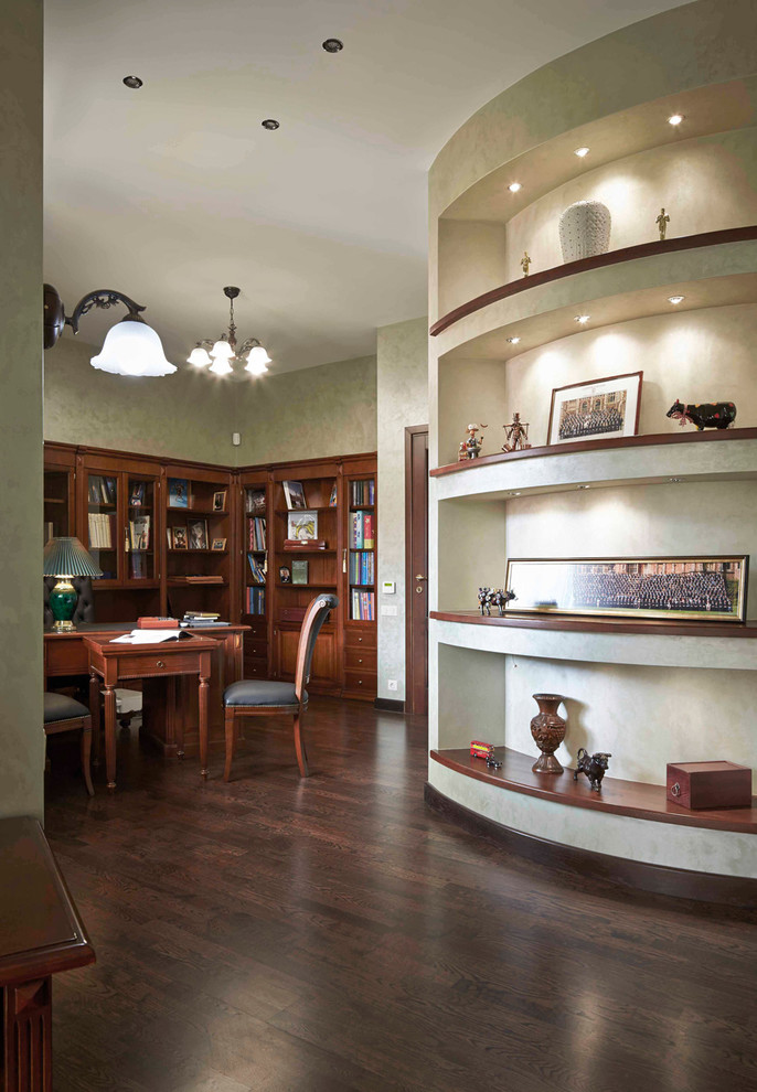 Réalisation d'un grand bureau tradition avec un mur vert, un sol en bois brun, un bureau indépendant et un sol marron.