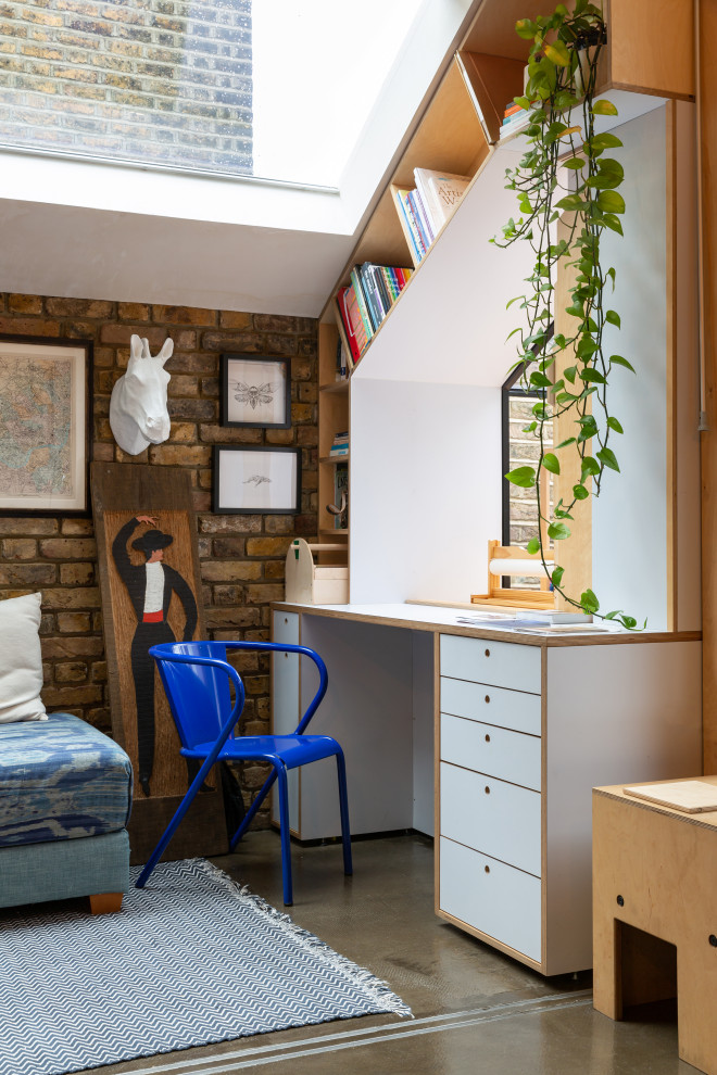 ロンドンにあるエクレクティックスタイルのおしゃれなホームオフィス・書斎 (茶色い壁、コンクリートの床、造り付け机、グレーの床) の写真