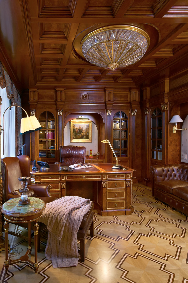 This is an example of a traditional study in Moscow with brown walls, light hardwood flooring, a freestanding desk and brown floors.