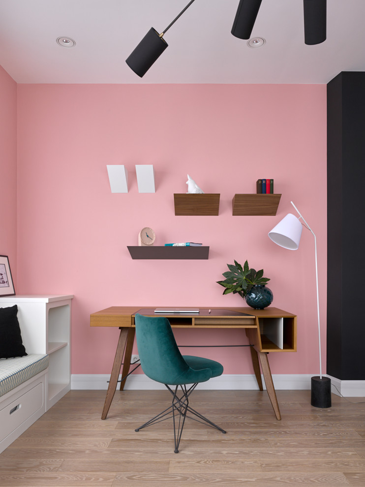 Idéer för ett modernt hemmabibliotek, med rosa väggar, ljust trägolv, ett fristående skrivbord och beiget golv