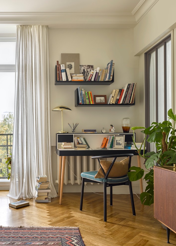 Idéer för ett modernt hemmabibliotek, med mellanmörkt trägolv och ett fristående skrivbord