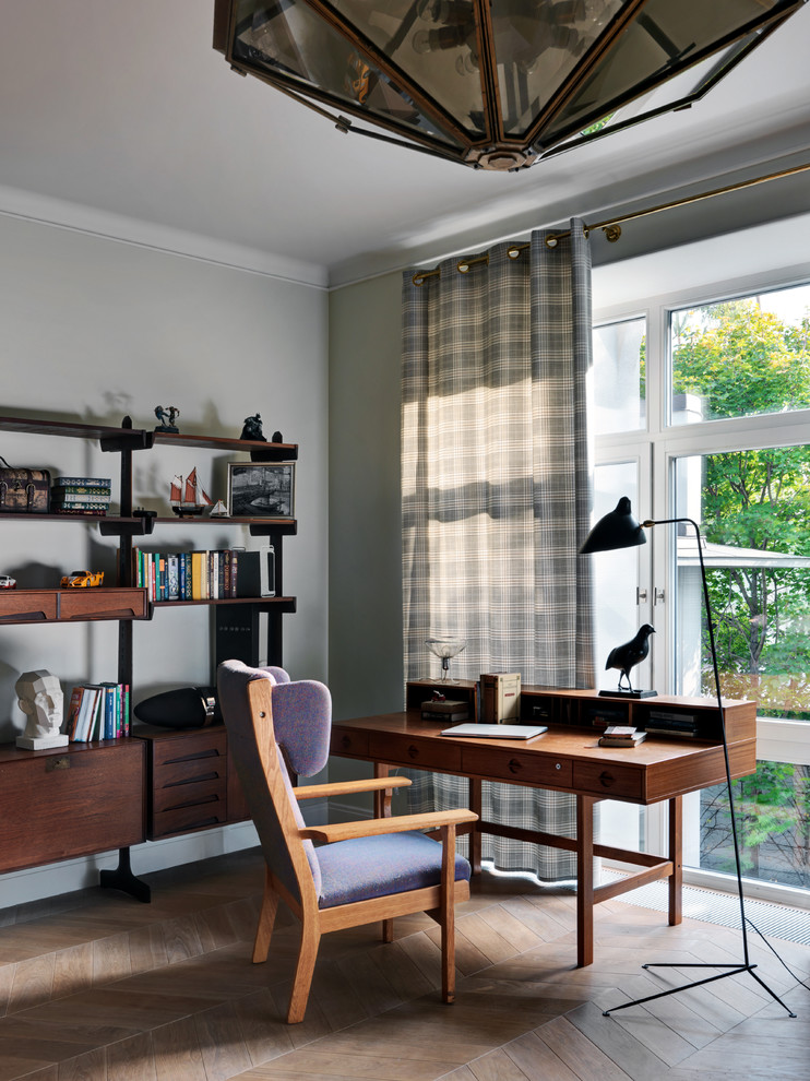 Cette photo montre un bureau chic avec un mur gris, parquet clair, un bureau indépendant et un sol marron.
