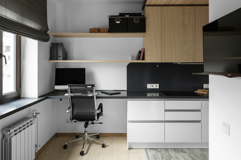 Ejemplo de despacho contemporáneo con paredes blancas, suelo de madera clara, escritorio empotrado y suelo beige