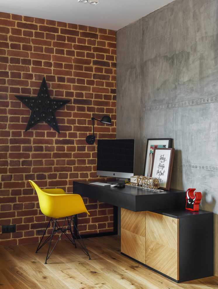 Idee per un ufficio industriale con pareti marroni, pavimento in legno massello medio, scrivania autoportante e pavimento marrone