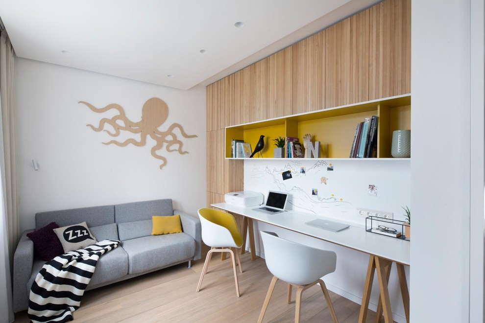 Diseño de despacho actual sin chimenea con paredes blancas, suelo de madera en tonos medios, escritorio independiente y suelo marrón