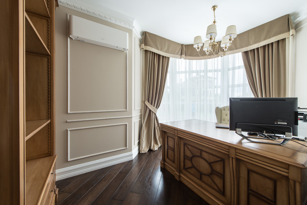Classic study in Moscow with beige walls, dark hardwood flooring and a freestanding desk.