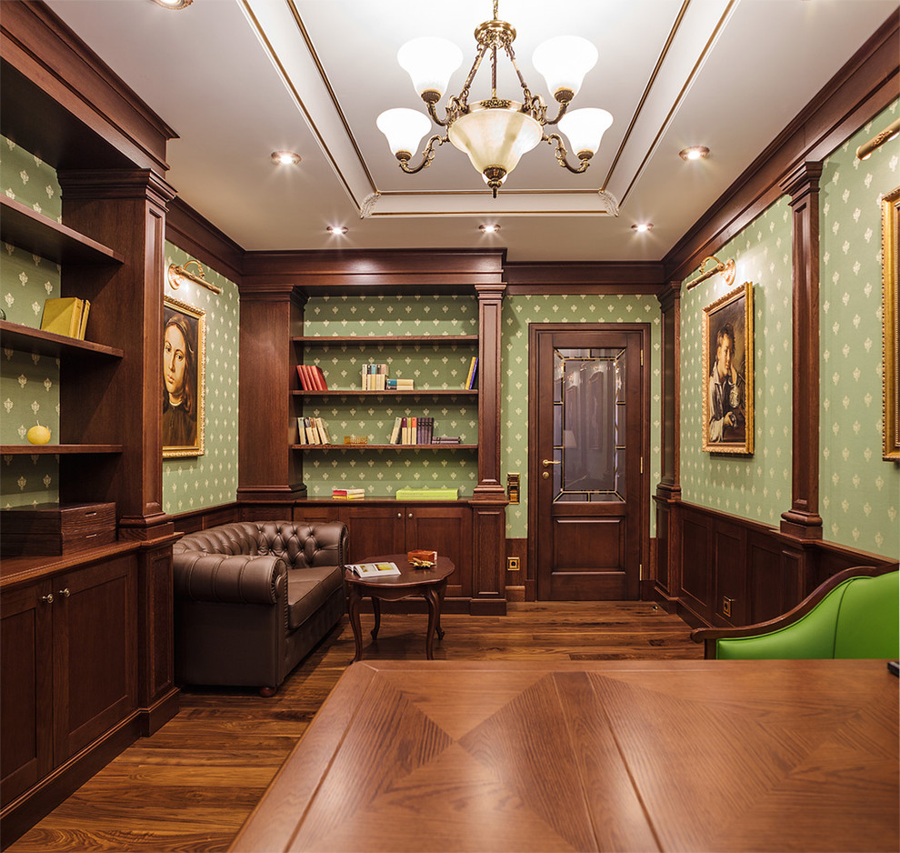 Стильный дизайн: домашняя библиотека в классическом стиле с зелеными стенами, паркетным полом среднего тона и коричневым полом - последний тренд