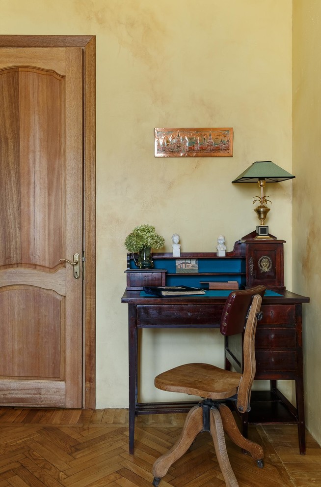 Modelo de despacho vintage pequeño con paredes beige, suelo de madera en tonos medios, escritorio independiente y suelo beige