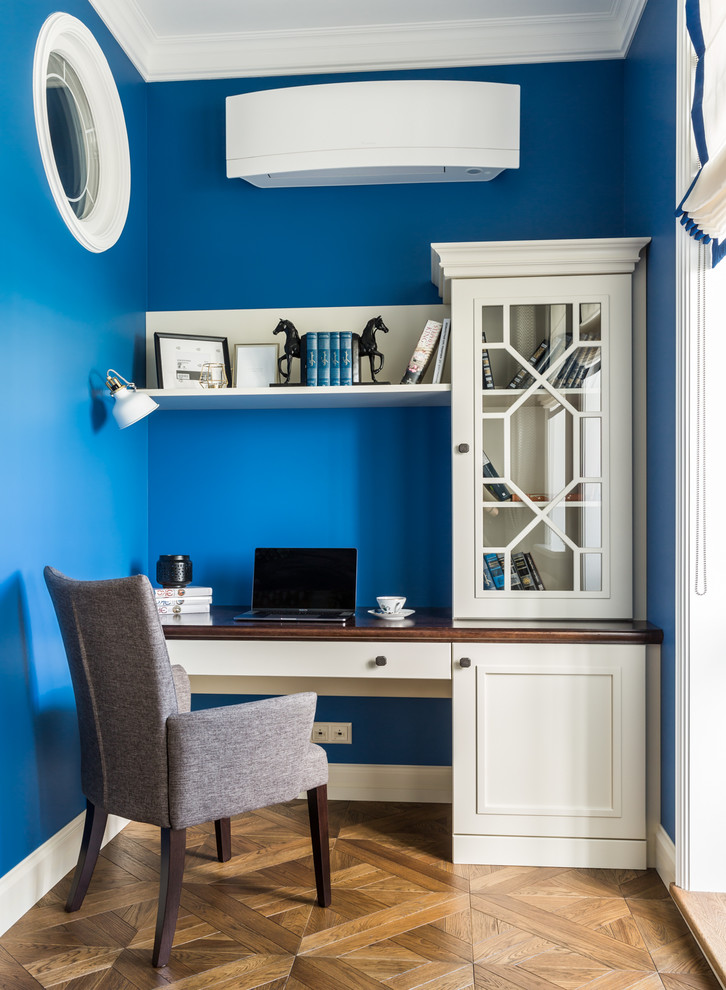 Пример оригинального дизайна: рабочее место среднего размера в стиле неоклассика (современная классика) с синими стенами, темным паркетным полом, отдельно стоящим рабочим столом, коричневым полом, кессонным потолком и обоями на стенах без камина