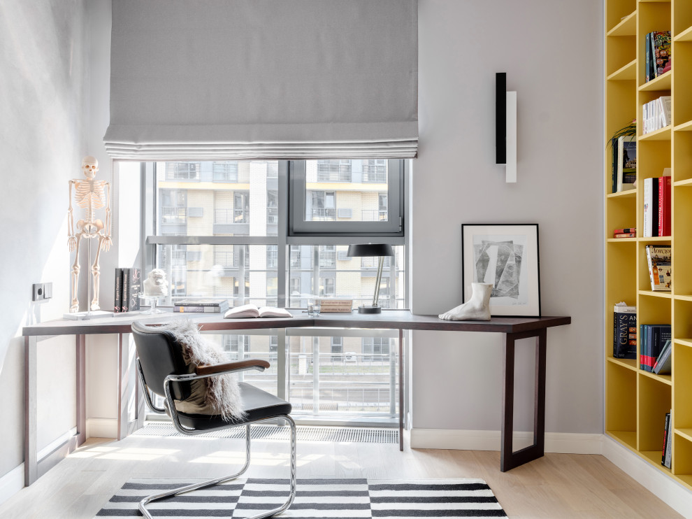 Foto de despacho contemporáneo con paredes grises, suelo de madera clara, escritorio independiente y suelo beige