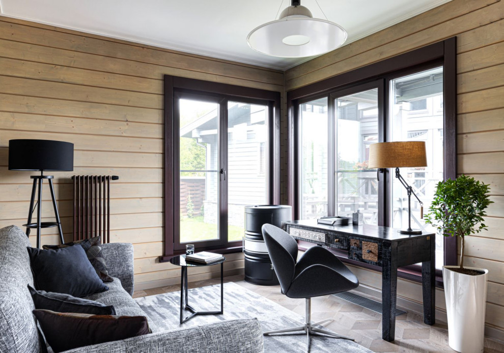 Ejemplo de despacho actual de tamaño medio con paredes beige, suelo de madera en tonos medios, escritorio independiente y suelo marrón