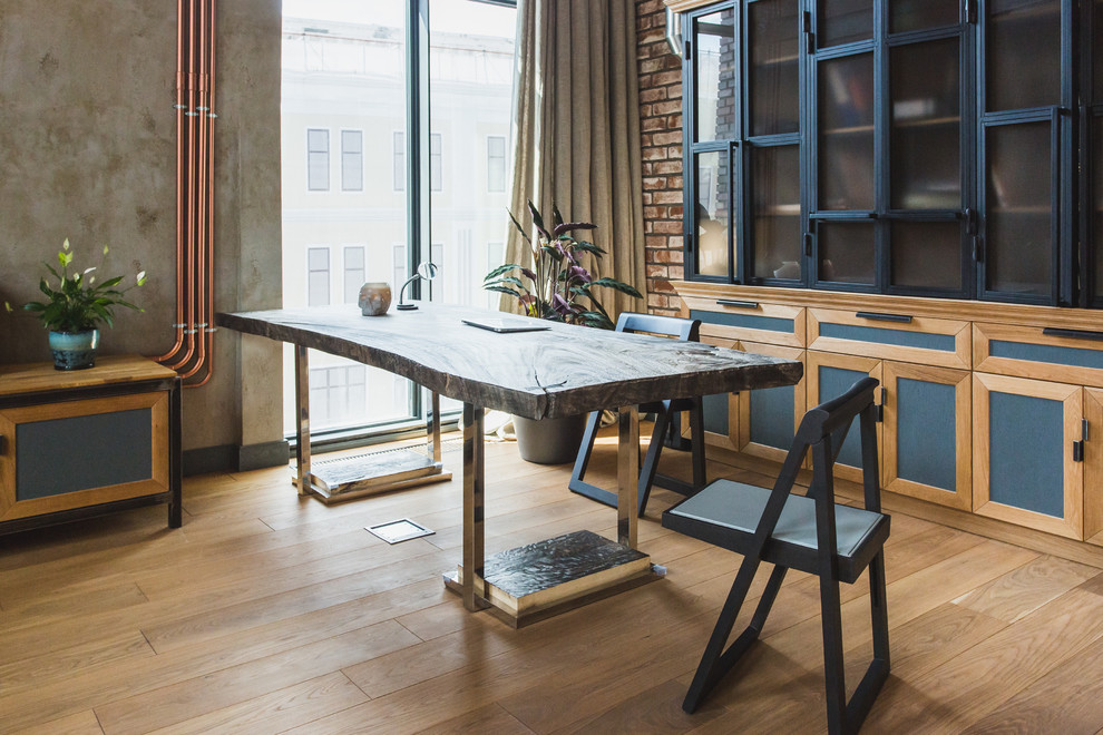 Industrial Arbeitszimmer mit Arbeitsplatz, grauer Wandfarbe, hellem Holzboden und freistehendem Schreibtisch in Moskau