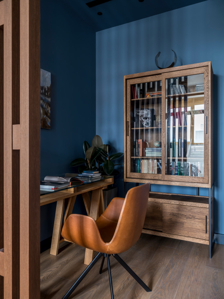 Пример оригинального дизайна: маленький кабинет в современном стиле с синими стенами, паркетным полом среднего тона, отдельно стоящим рабочим столом и коричневым полом для на участке и в саду