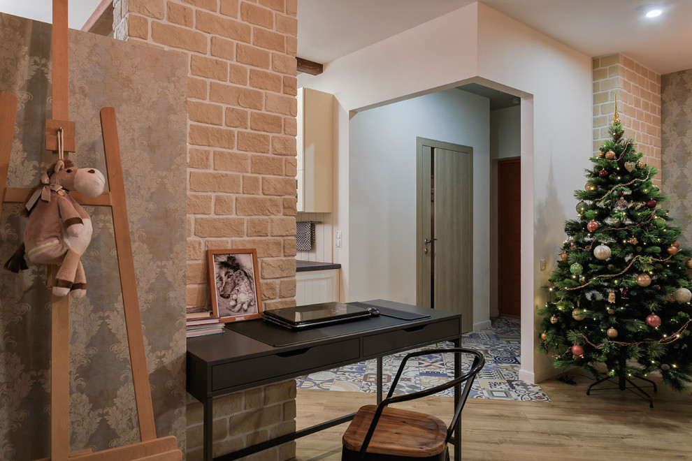 Ejemplo de despacho bohemio pequeño con paredes multicolor, suelo de madera clara y escritorio independiente