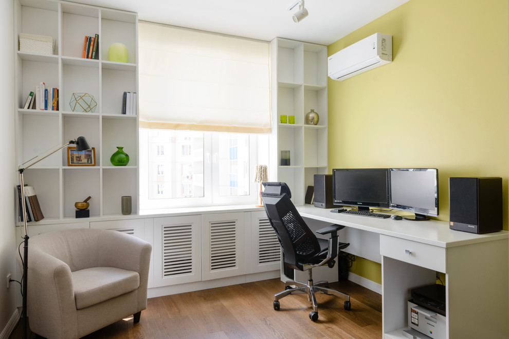 Exemple d'un bureau tendance de taille moyenne avec un sol en bois brun, un bureau indépendant et un mur vert.