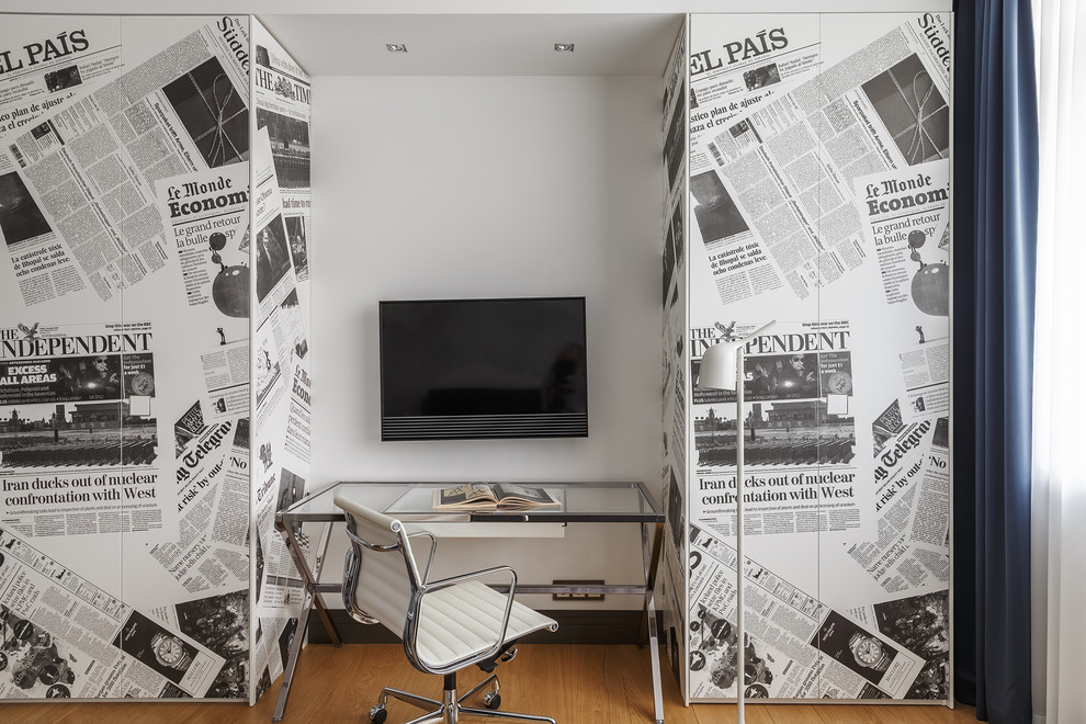 На фото: рабочее место в современном стиле с белыми стенами, паркетным полом среднего тона, отдельно стоящим рабочим столом и коричневым полом
