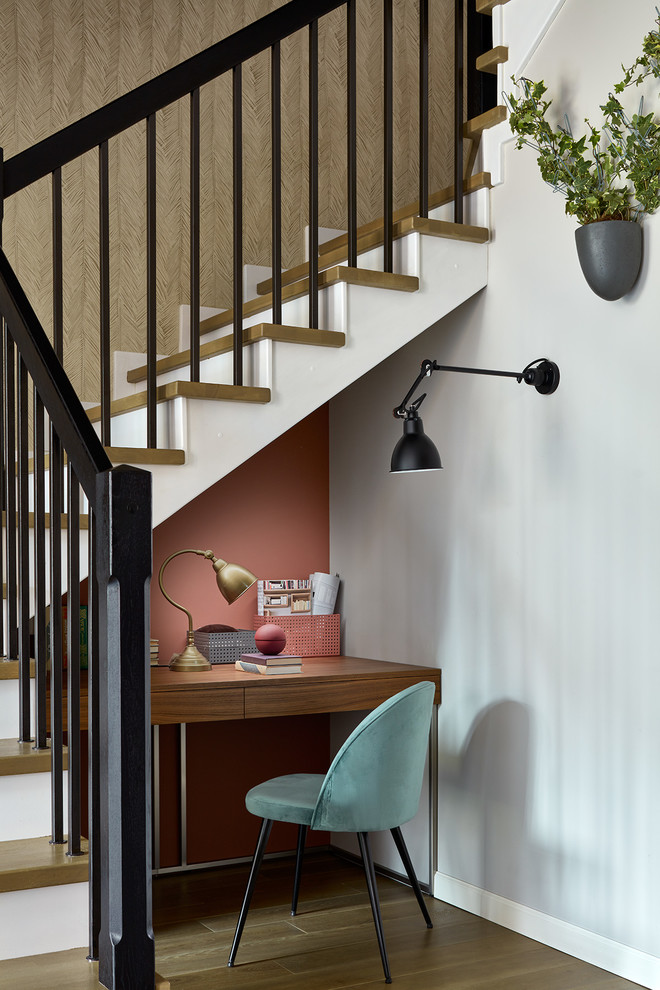Ejemplo de despacho actual pequeño sin chimenea con escritorio empotrado, suelo de madera en tonos medios y paredes rosas