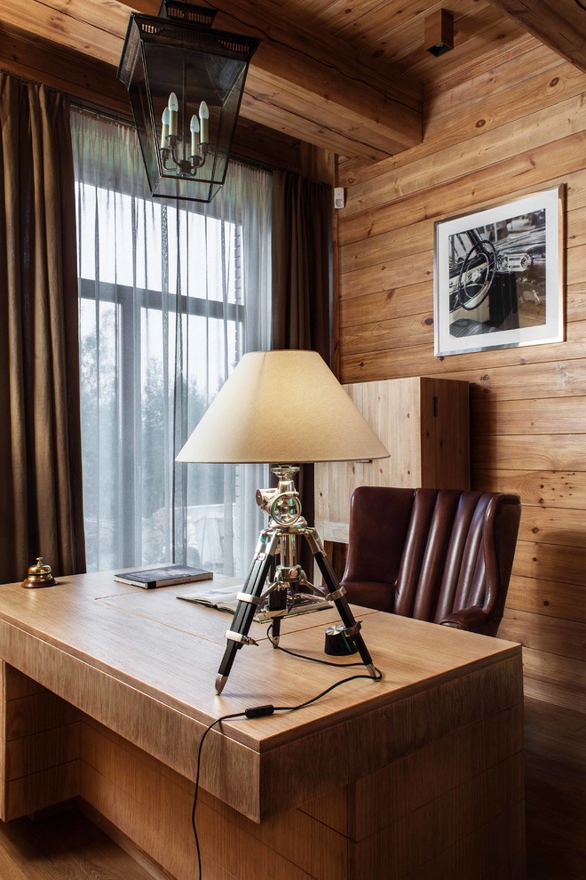 Inspiration for a rustic study in Moscow with brown walls and a freestanding desk.