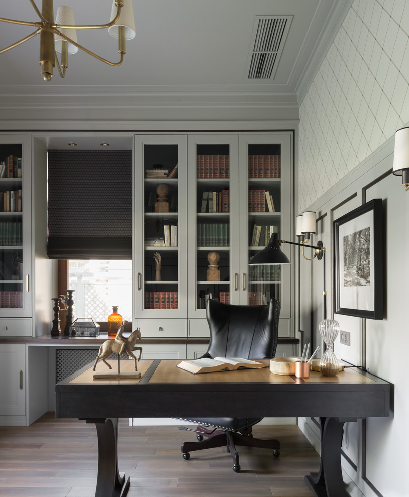 Immagine di un ufficio chic con pareti grigie, pavimento in legno massello medio, scrivania autoportante e pavimento marrone