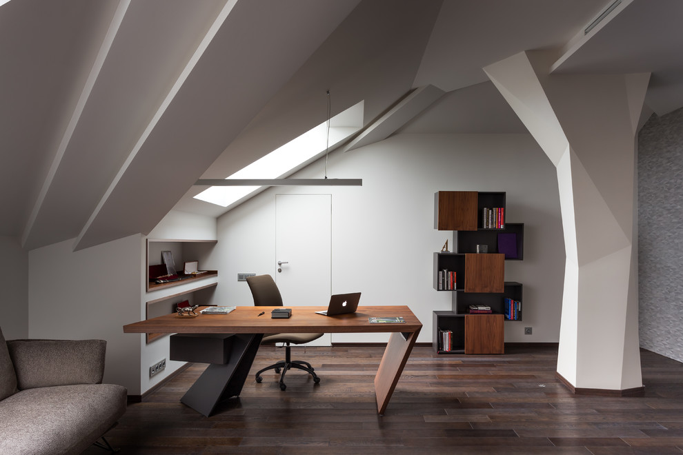 Modernes Arbeitszimmer mit weißer Wandfarbe, dunklem Holzboden, freistehendem Schreibtisch und braunem Boden in Moskau