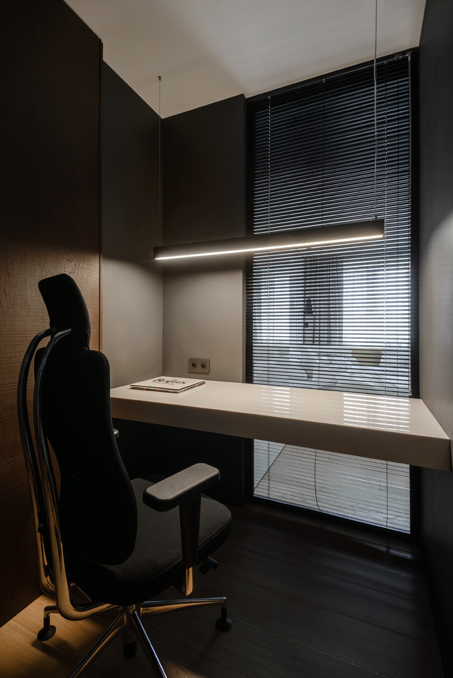 На фото: рабочее место в современном стиле с серыми стенами и встроенным рабочим столом с