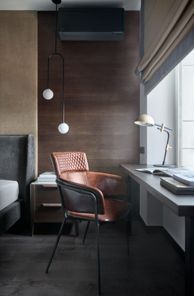На фото: рабочее место среднего размера в современном стиле с коричневыми стенами, встроенным рабочим столом и черным полом с