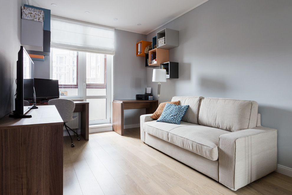 Idéer för ett mellanstort modernt hemmastudio, med grå väggar, ljust trägolv, ett fristående skrivbord och turkost golv