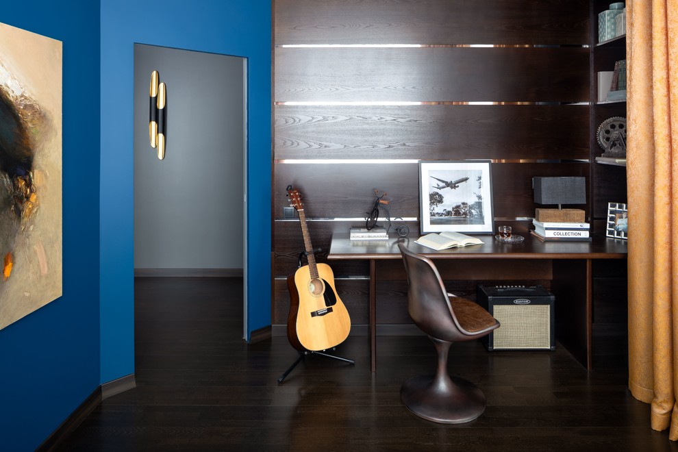 Пример оригинального дизайна: рабочее место среднего размера в современном стиле с синими стенами, темным паркетным полом, встроенным рабочим столом и коричневым полом