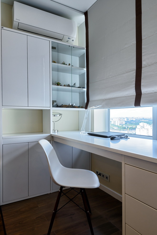 Idée de décoration pour un bureau design avec un mur beige, parquet foncé et un bureau intégré.