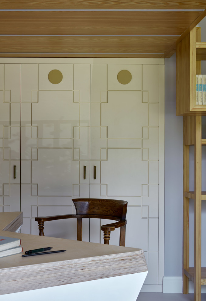 Стильный дизайн: рабочее место среднего размера в современном стиле с серыми стенами, бетонным полом, отдельно стоящим рабочим столом и белым полом - последний тренд