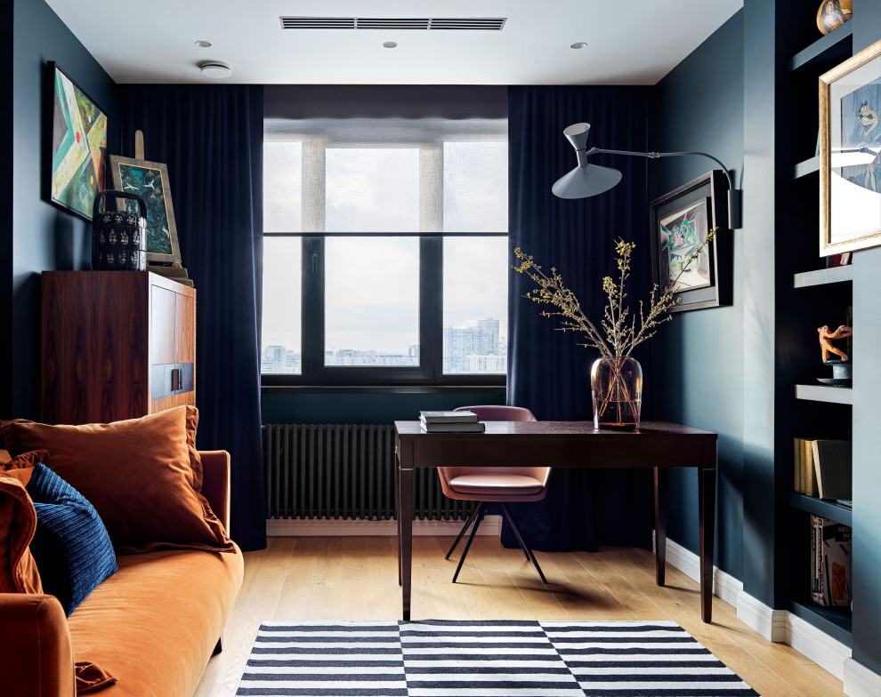 Пример оригинального дизайна: рабочее место среднего размера в стиле неоклассика (современная классика) с синими стенами, отдельно стоящим рабочим столом и коричневым полом
