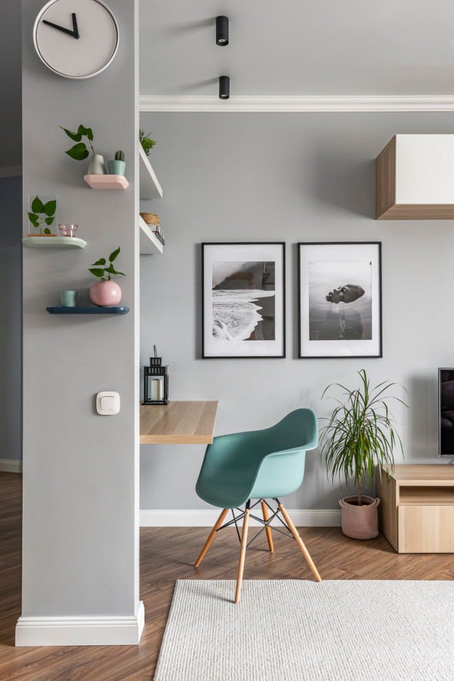 Cette photo montre un bureau scandinave avec un mur gris, un sol en bois brun, un bureau intégré et un sol marron.