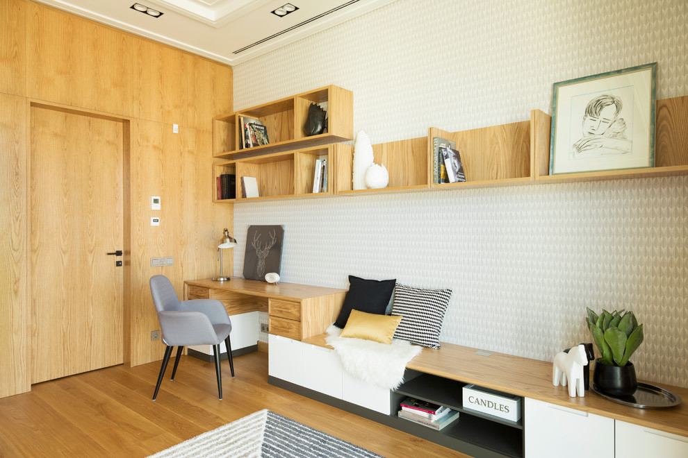 Foto på ett funkis hemmabibliotek, med flerfärgade väggar, ljust trägolv och ett inbyggt skrivbord
