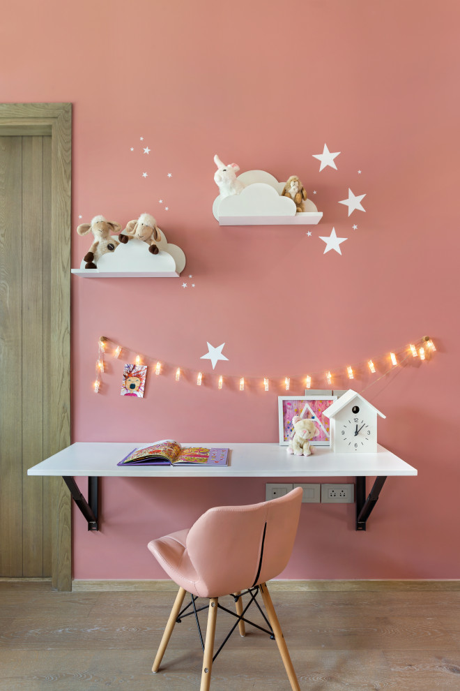 Inspiration for a contemporary kids' study space for girls in Mumbai with pink walls, light hardwood flooring and beige floors.