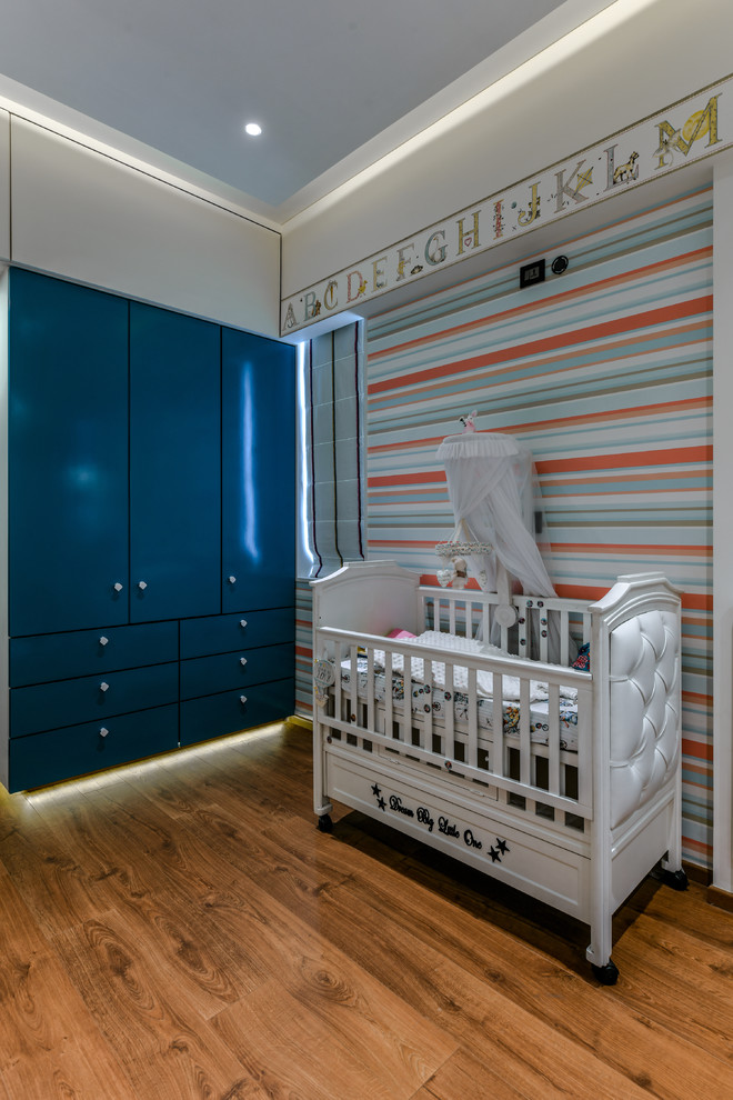 Immagine di una cameretta per neonati eclettica