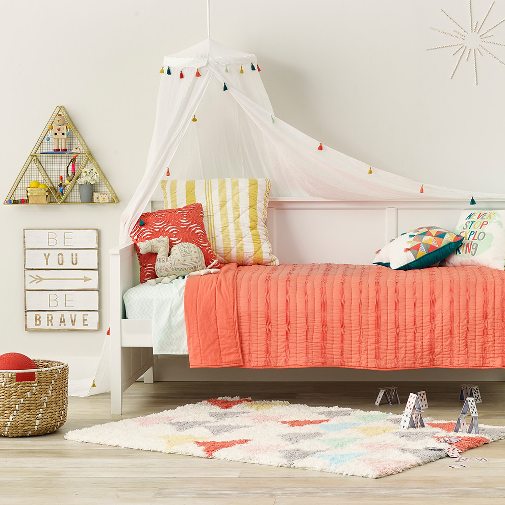 Esempio di una cameretta per bambini da 4 a 10 anni minimalista di medie dimensioni con pareti beige, parquet chiaro e pavimento beige
