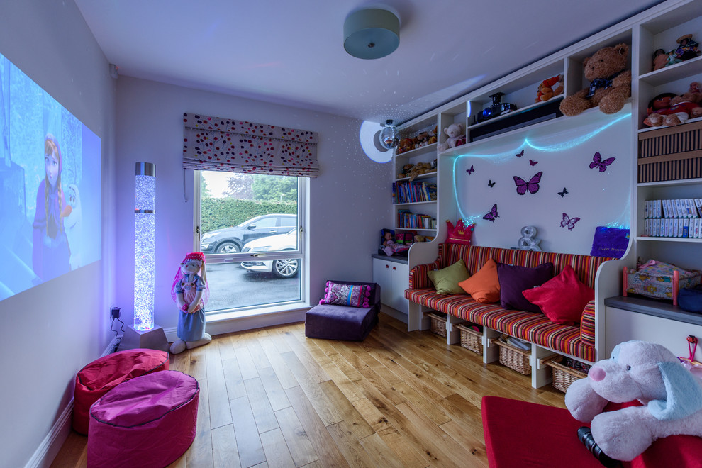 Mittelgroßes Modernes Mädchenzimmer mit Spielecke, lila Wandfarbe, hellem Holzboden und braunem Boden