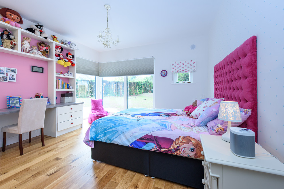 Modelo de dormitorio infantil de 4 a 10 años actual de tamaño medio con paredes blancas, suelo de madera clara y suelo beige