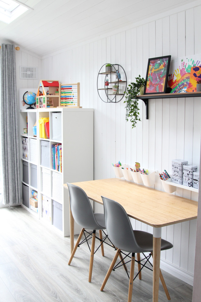 Foto di una piccola cameretta per bambini da 1 a 3 anni minimalista con pareti bianche, pavimento in laminato e pavimento grigio